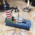 Cast Iron Lighthouse & Sailboat Mechanical Coin Bank | Bits & Pieces